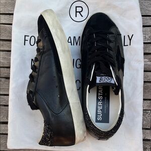 Golden Goose Women's Super-Star Black Nappa Sneakers with Glitter Heel Tab.
